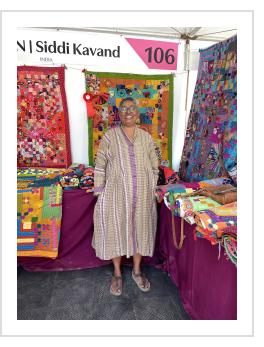 Artist Anitha N with Innovation Award-winning Siddi quilt at 2025 International Folk Art Market.