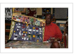 Senior painter Mohammed Charinda with his painting "Tinga Tinga Art Studio", 2013 (see below).. Photo courtesy of Tinga Tinga Arts Cooperative Society, 2013)