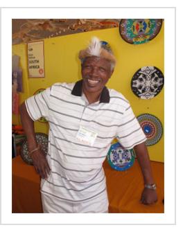 Elliot Mkhize with some of his work at the 2014 International Folk Art Market. (Photograph © Anthony Hart Fisher 2014)