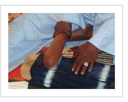 Ousmane Ganamé pounding indigo fabric smooth to finish it. (Photograph © Anthony Hart Fisher 2003).
